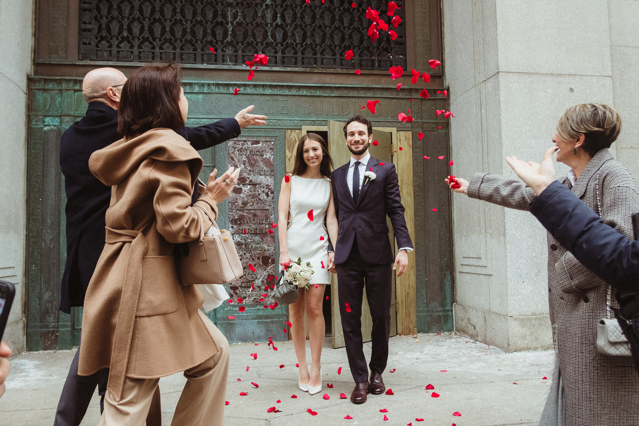 couple with flower petals thrown on them nyc city hall